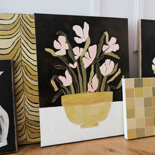 Original oil painting titled Fresh Cuts by Alex King featuring blush pink flowers with green stems arranged in a yellow ceramic bowl against a black background in a contemporary floral still life.
